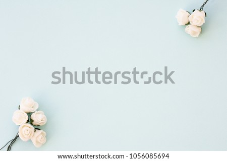 Styled stock photo. Feminine wedding desktop mockup. White roses on delicate blue background. Copy space. Top view. Picture for blog