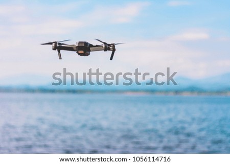 drone quad copter  with high resolution digital camera flying the sky with lake view