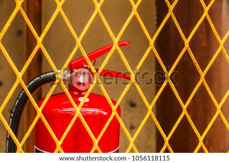 Yellow Steel cage with Dry chemical fire extinguisher industrial factory.