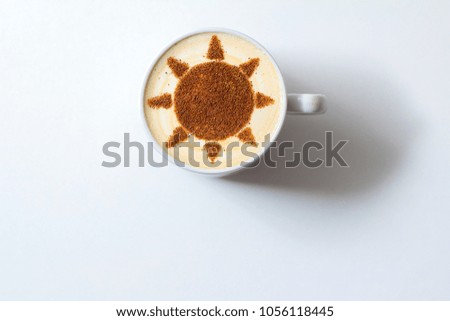 Cappuccino in a white cup with a picture of the sun on milk foam