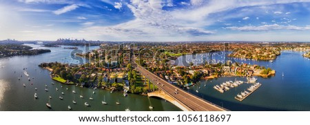Parramatta river in Sydney west flowing from western suburbs to Sydney harbour and city CBD. Aerial view from Gladesville bridge to Drummoyne with lots of marine yachts. Royalty-Free Stock Photo #1056118697