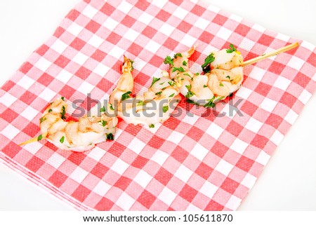 Little prawn snacks on wooden tray over white background