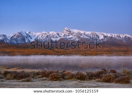 First snow on Lake. Colorful autumn landscape.