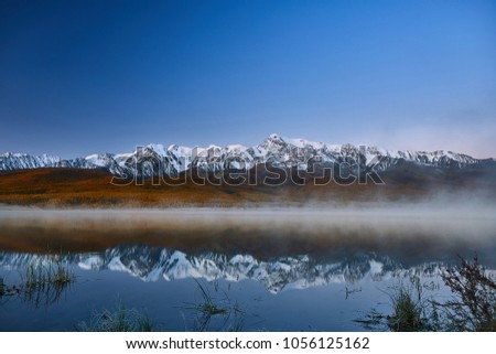 First snow on Lake. Colorful autumn landscape.