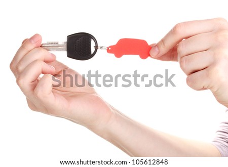 Car key with charm in hands isolated on white