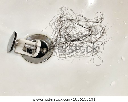 Young woman brushing her hair. Many hair loss on filter in washbasin in bathroom. Healthcare, medical concept. Copy space. Royalty-Free Stock Photo #1056135131