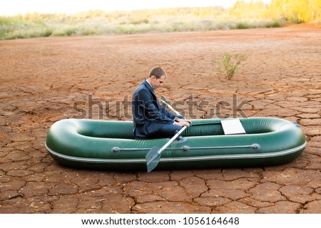 sad funny Business man stop on crack soil hot land desert boat businessman rock look bright future symbol crisis stagnation losses braking difficulties environmental disaster water scarcity drought Royalty-Free Stock Photo #1056164648