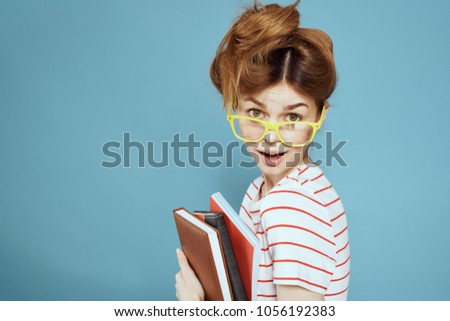 student in glasses with notebooks                     
