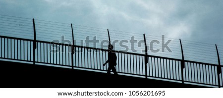 Silhouette bridge and walking people. Blue sky and clouds in summertime. People who are walking, have healthy lifestyle.