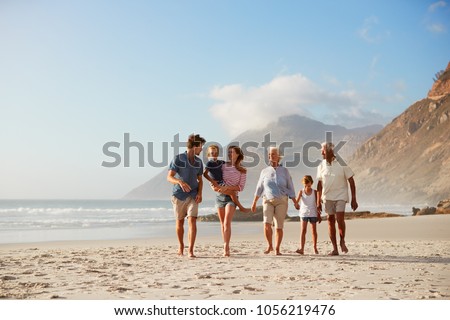 Multi Generation Family On Vacation Walking Along Beach Together Royalty-Free Stock Photo #1056219476