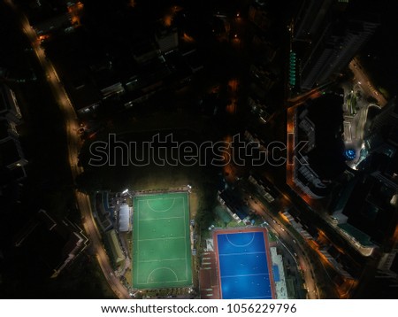 Aerial view of outdoor hockey field during night. The image contains soft focus, grain and noise.