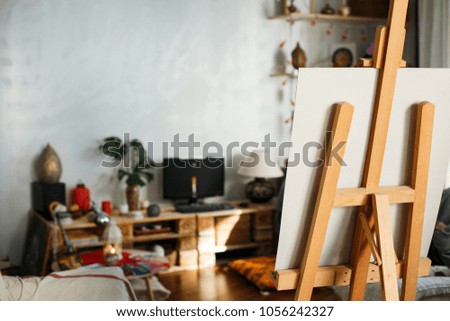 Artistic equipment: artist paper or canvas on easel in an artist studio. Cozy room of creative people
