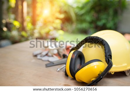 Standard construction safety equipment on wooden table. Royalty-Free Stock Photo #1056270656
