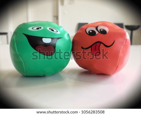 Two funny softballs with faces on them
