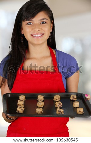 Teen girl baking cookies in her kitchen