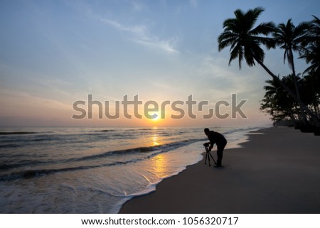 
The photographer is taking a picture of the morning sun at a beach in southern Thailand.