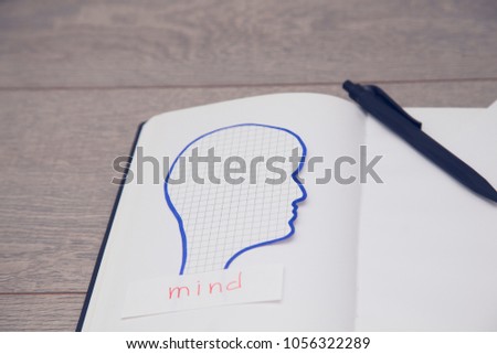Sign Mind on wood board background. Mens head siluet. Take note of the product for book with paper and concept or copy space.