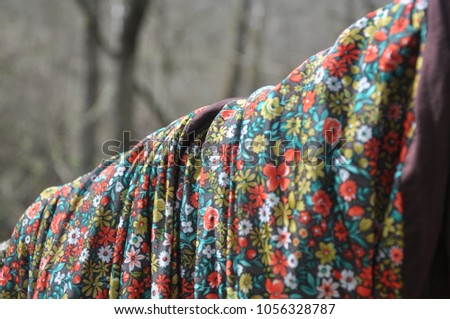 Colorful scarf in flower wrapped on a fallen tree in a forest