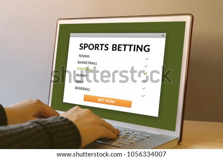 Sports betting concept on laptop computer screen on wooden table. Hands typing on a keyboard. All screen content is designed by me. 