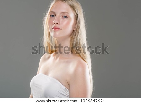 Beauty Woman face Portrait. Beautiful model Girl with Perfect Fresh Clean Skin over gray background. Studio shot.