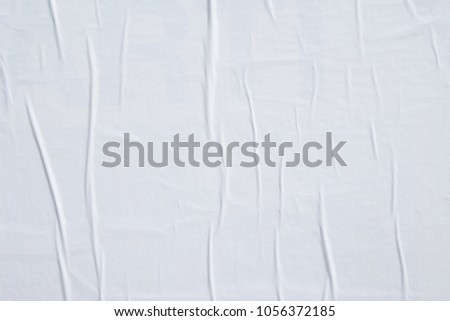 a white empty weathered wrinkled urban billboard paper poster texture  Royalty-Free Stock Photo #1056372185