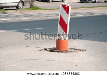 Street reconstruction or construction barricade caution red and white sign cover the open hole of manhole on the road as a precaution in the traffic, traffic security concept 