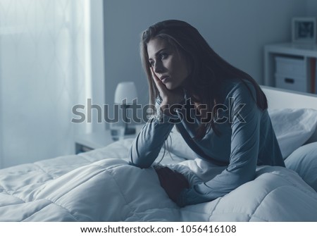Depressed woman awake in the night, she is exhausted and suffering from insomnia Royalty-Free Stock Photo #1056416108
