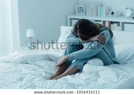 Depressed woman awake in the night, she is exhausted and suffering from insomnia Royalty-Free Stock Photo #1056416111