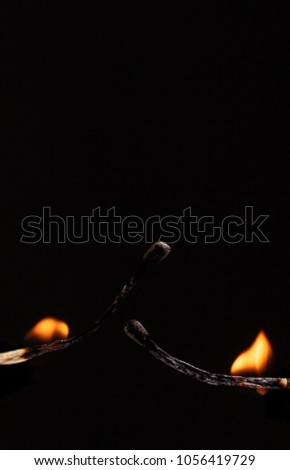 two burning match with the flame isolated on black background