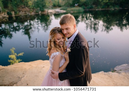 groom tenderly embraces the bride against the background of nature at sunset, close-up
