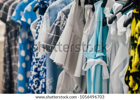 Rack with collection of clothes in dressing room, women's