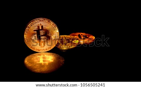 Bitcoin Banner depth of field blur copy space. Three gold Bitcoin with reflection on isolated copyspace black for text.