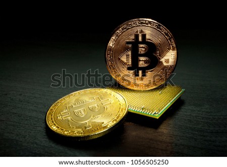 Closeup of crypto currency phisical bitcoin over aligned computer cpu processors on wooden background