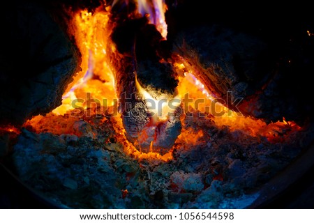 Fire in the fireplace, tongues of flame from a burning log on fire