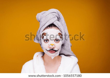 cute young girl with a towel on her head, on her face mask with a picture of an animal