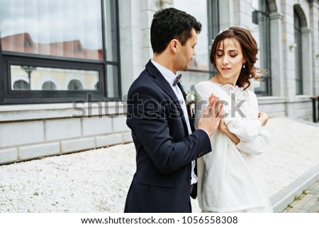 Bride whirls around groom's hand on the city square