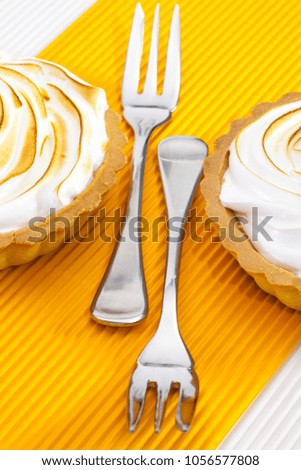 Two lemon tartalets on the white table.