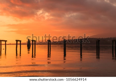 Sunset on the water with an old dock in the front