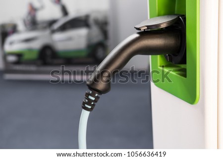 power plug of an electric vehicle charging station is waiting for the next car to charge Royalty-Free Stock Photo #1056636419