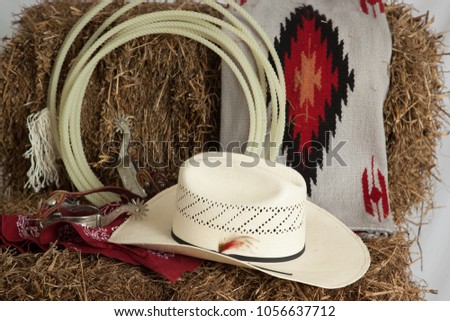 lasso spurs, and hat, on a bale of hay