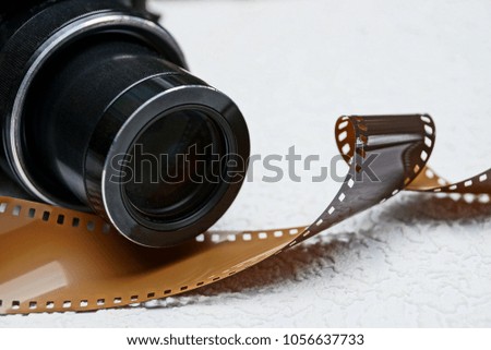 Part of a black camera and a brown film