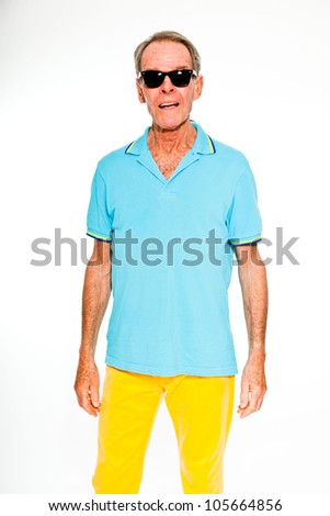 Expressive good looking senior man casual summer dressed against white wall. Wearing sunglasses. Happy, funny and characteristic. Isolated. Studio shot.