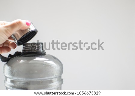 hand holding sports bottle grey on a light background