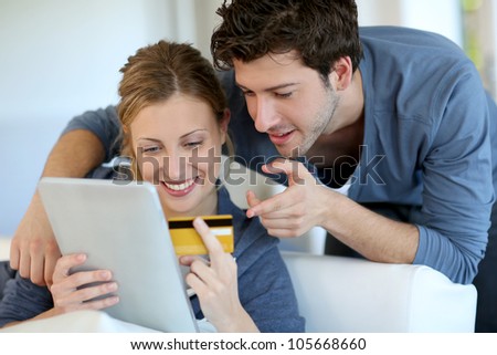 Young couple at home buying on internet Royalty-Free Stock Photo #105668660