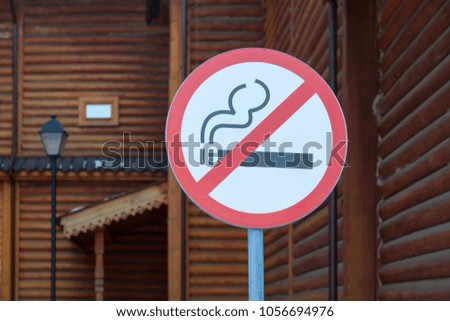 sign not to smoke on the background of buildings made of wood
