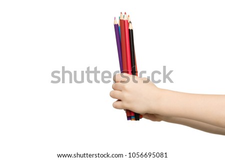 Children's hand holding stack of colorful pencils, isolated on white background. Art, creativity, education concept