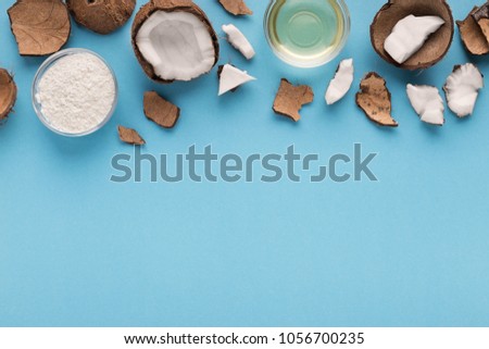 Plate with coconut gluten free flour, water and nuts on blue background, top view, copy space. Organic ingredients for cooking vegan meals. Nutritious exotic nuts.