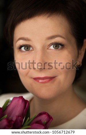 Beautiful woman with a bouquet of tulips flowers
