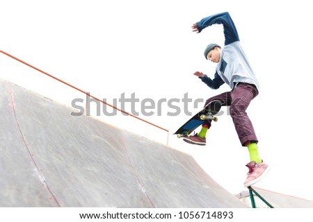 The teenager skateboarder in the cap does a trick with a jump on the ramp in the skatepark. Isolated skater and ramp on white background