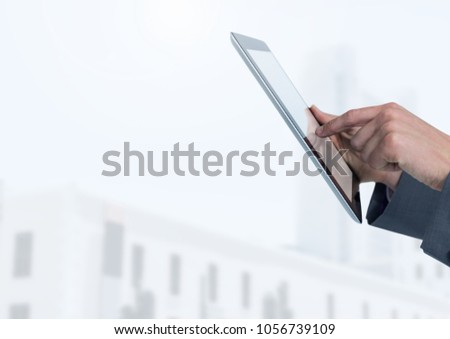 Digital composite of Businessman holding tablet in front of bright buildings